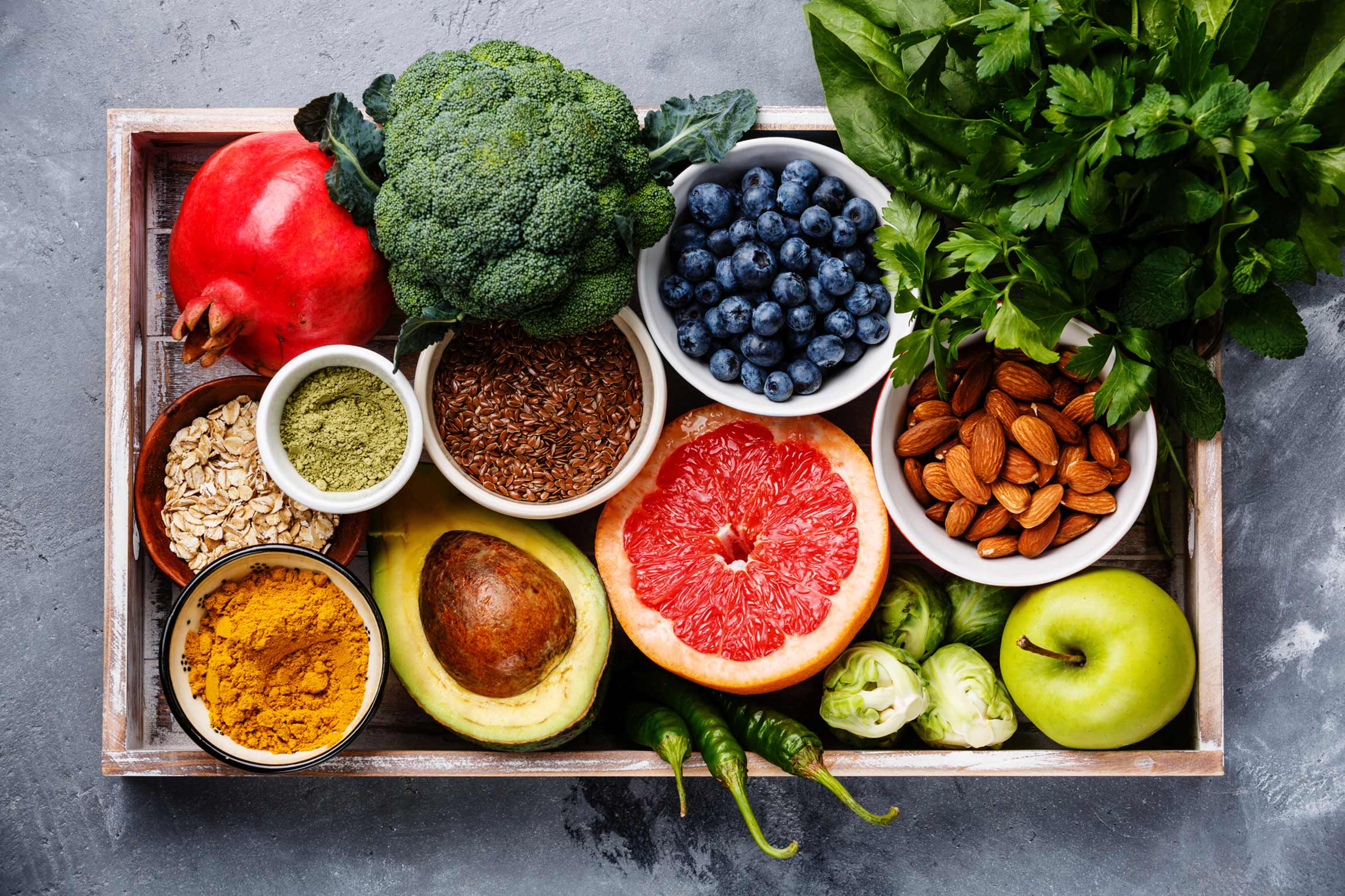 A tray full of fruits, vegetables, nuts, grains, and spices