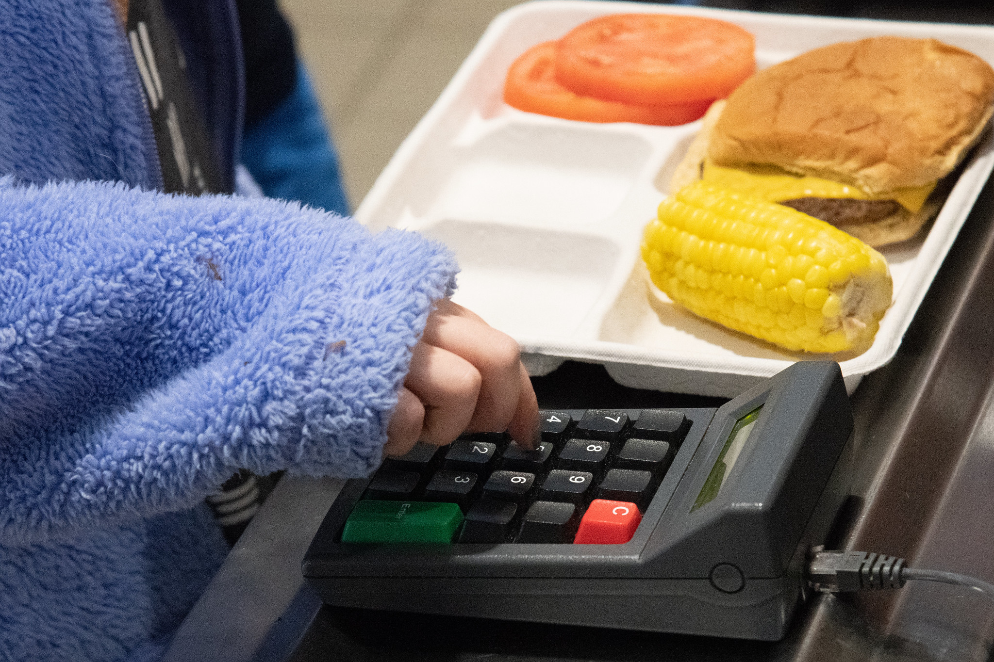 A student types in her lunch number while in the cafeteria