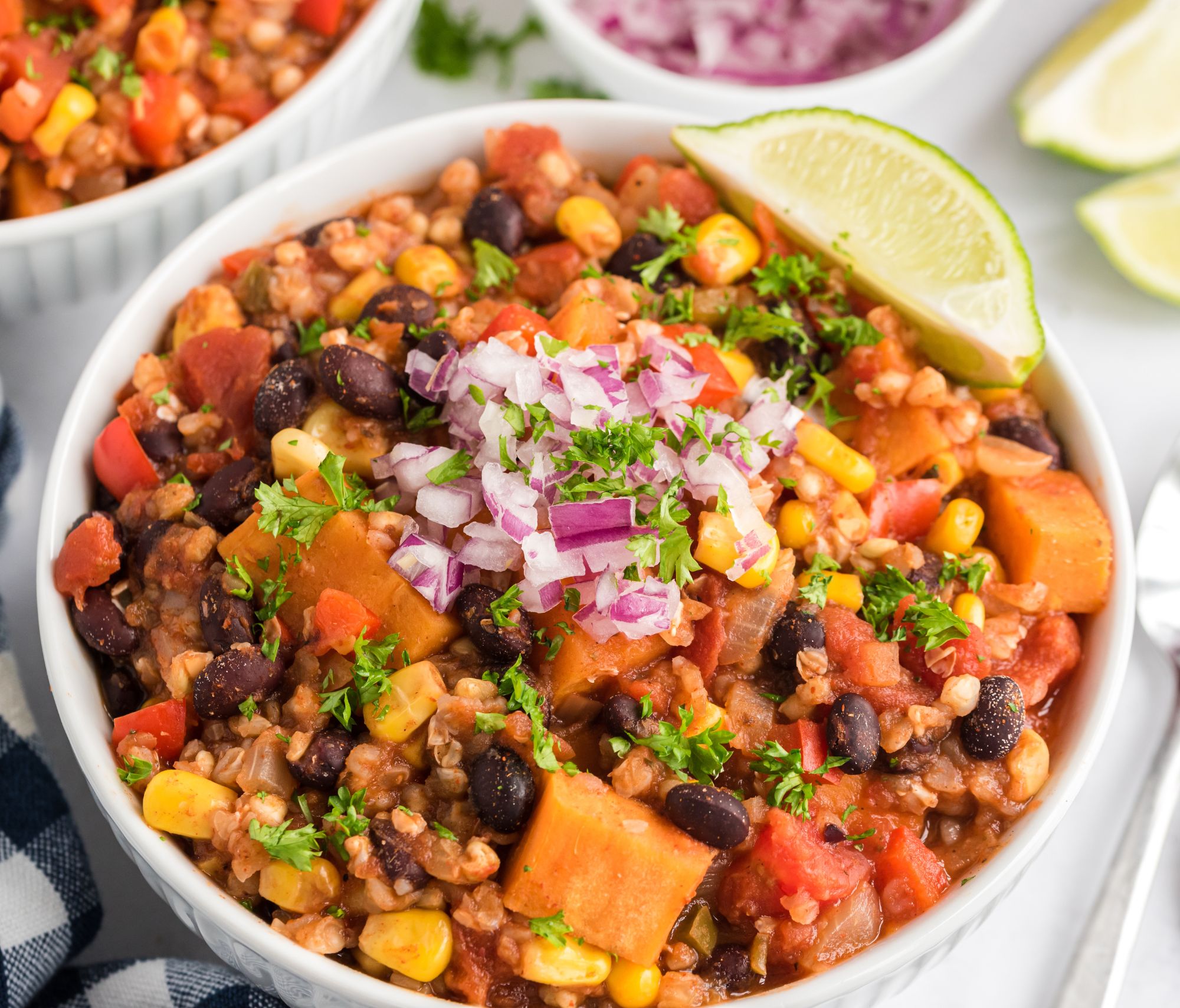 Buckwheat Sweet Potato Chili on a dish with a green lime garnished on top