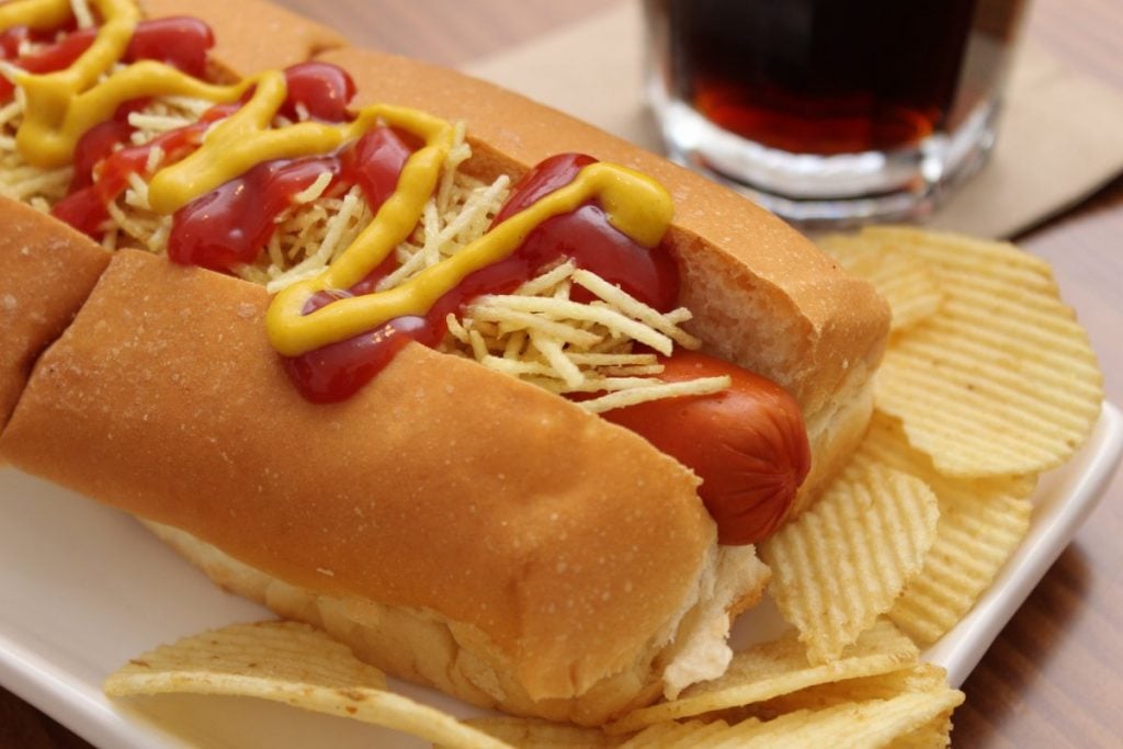 Hot dog with ketchup mustard chips and coke
