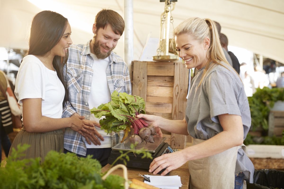 People purchasing beets at a farmers' market