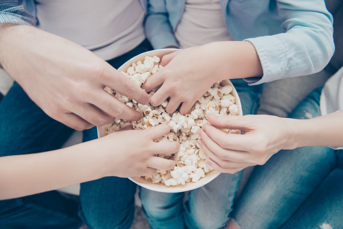 Hands in a bowl of popcorn