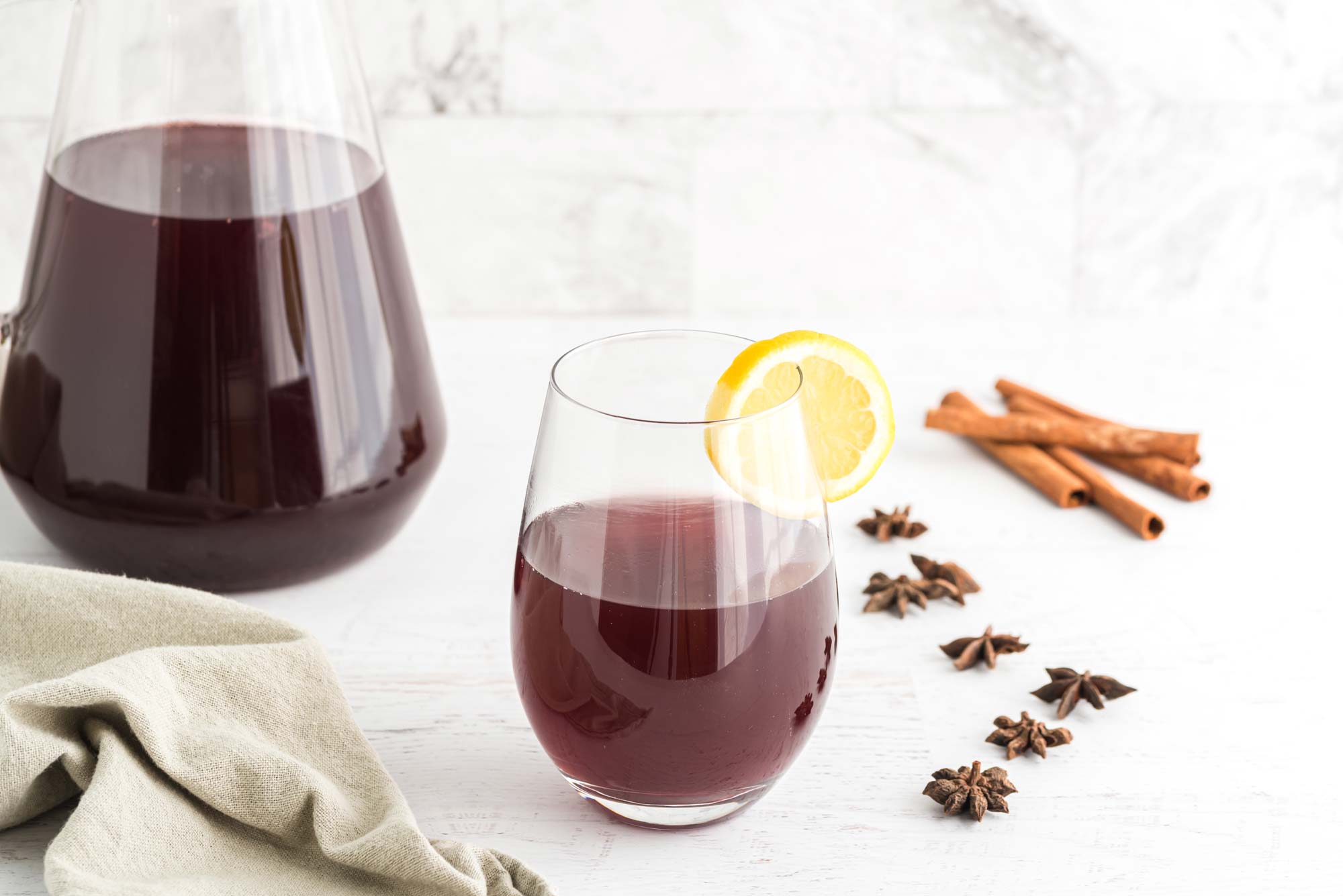 pomegranate sangria in glass with lemon wedge