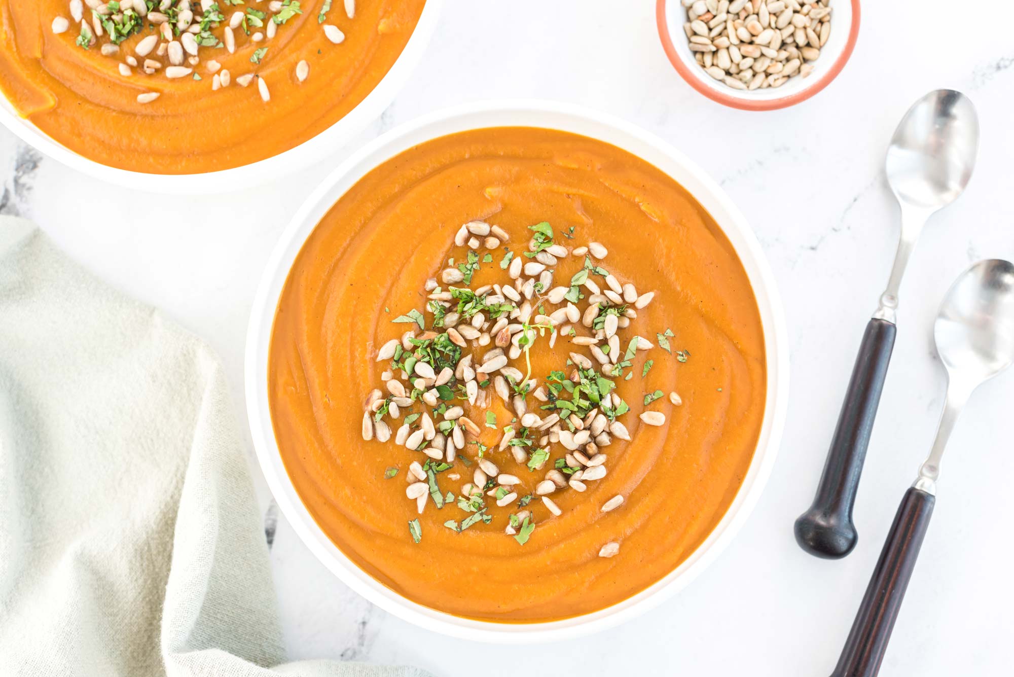 sweet potato carrot soup with toasted sunflower seeds in bowl