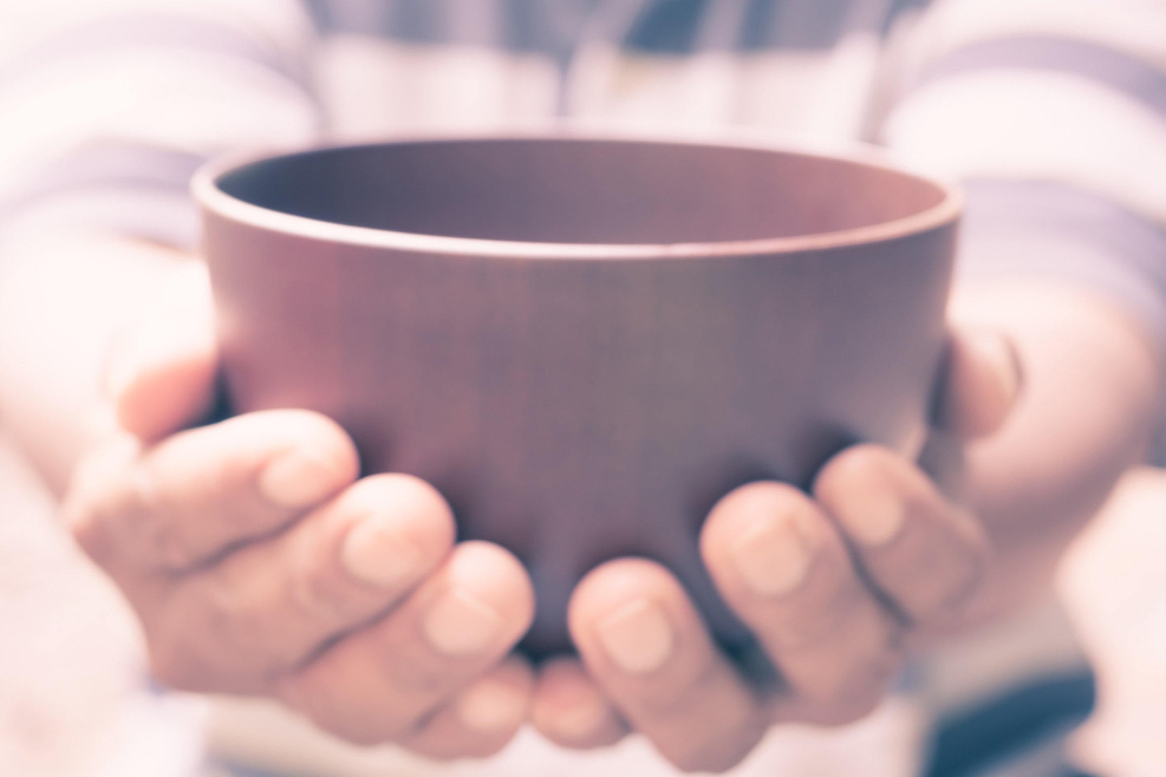 Hands around a bowl of soup