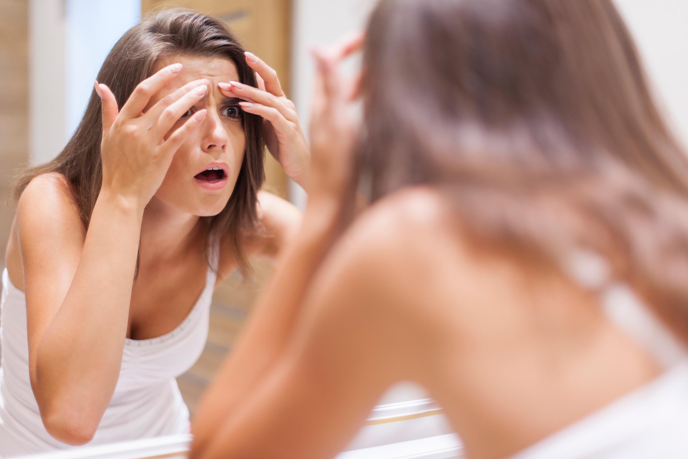 woman surprised by acne on forehead