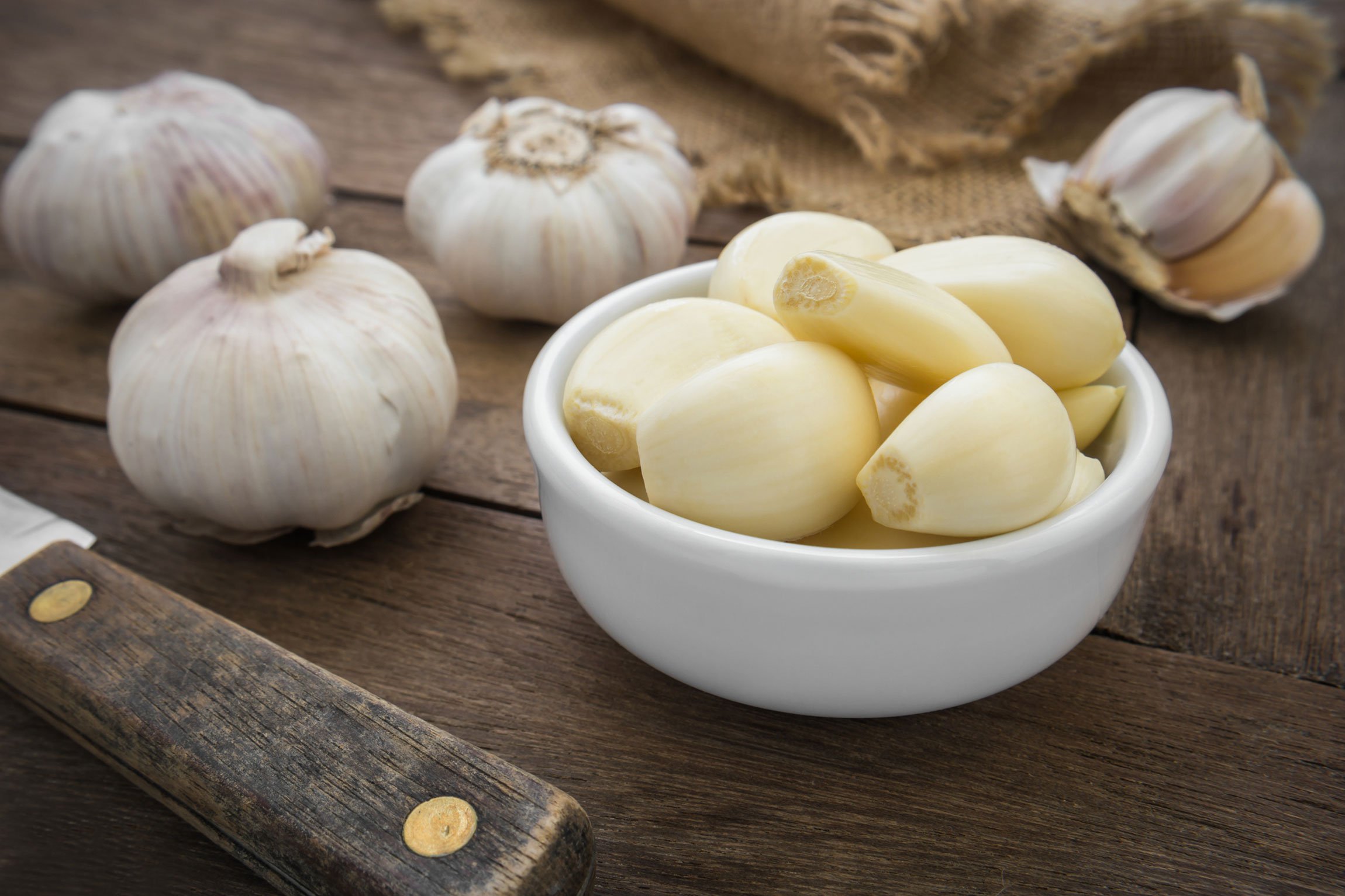 garlic bulbs, and skinned garlic cloves in a bowl