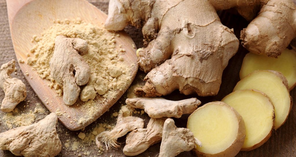 ground, cut, and whole ginger root on table