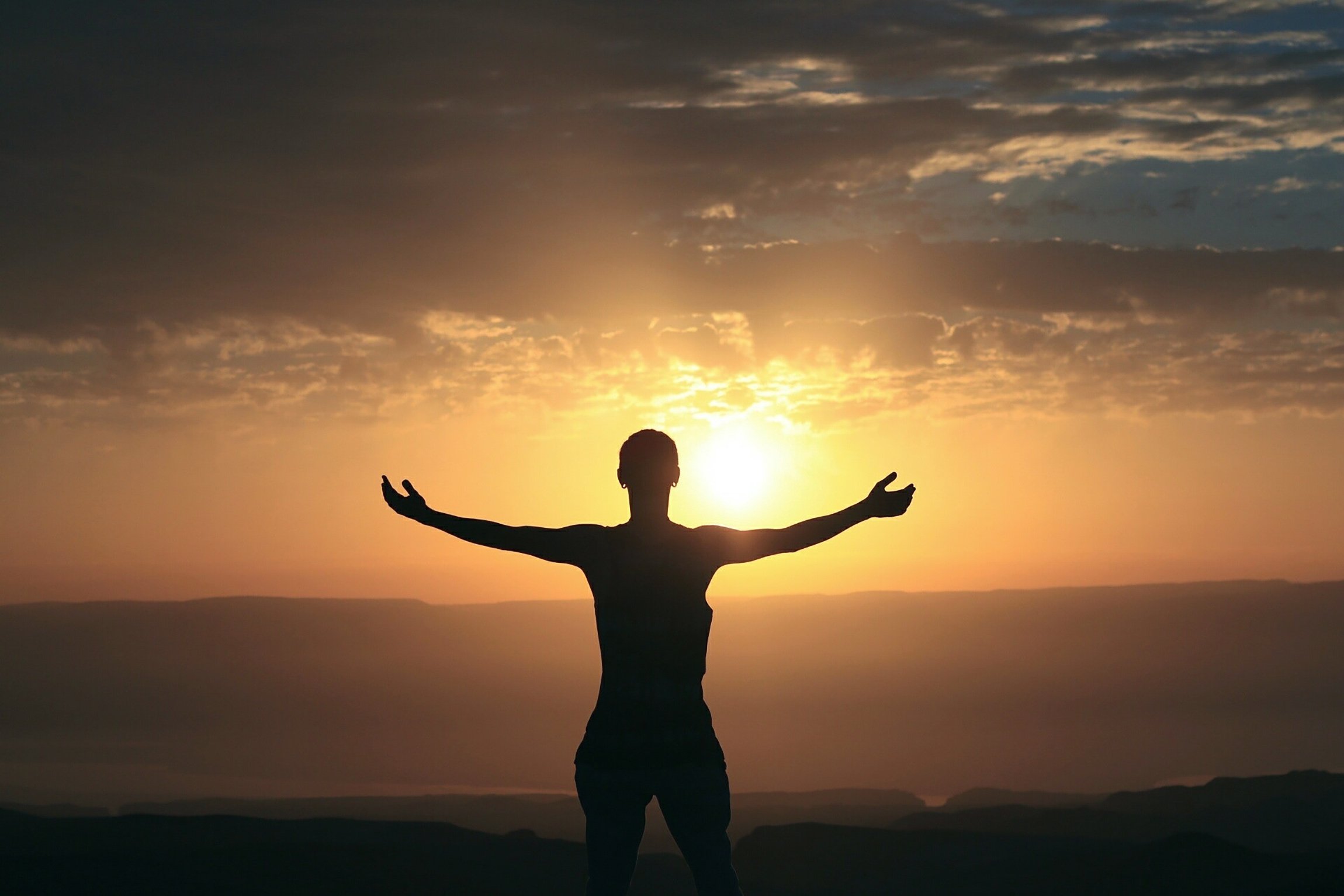 Lifting arms toward sunset