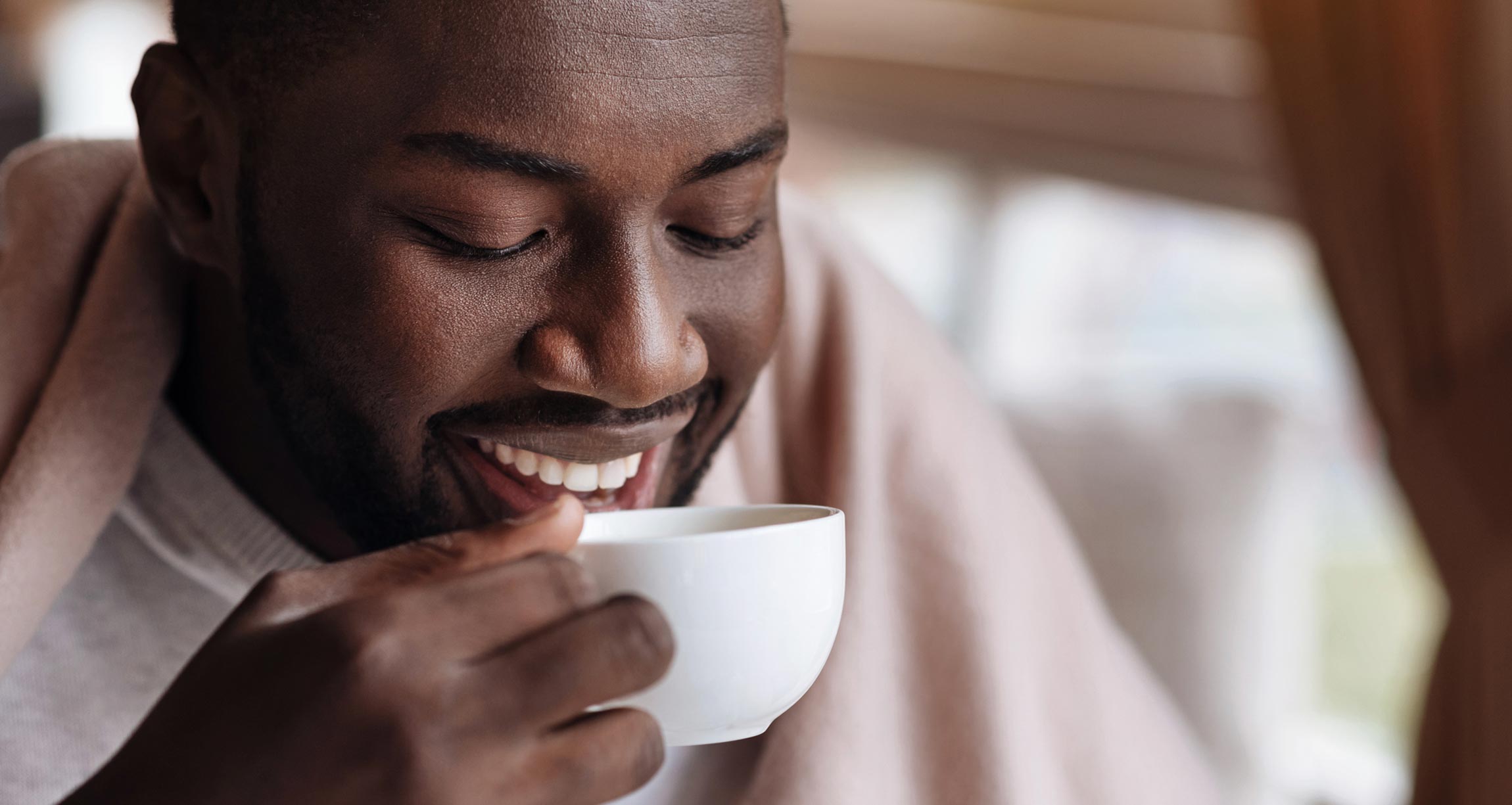 man smiling with coffee cup