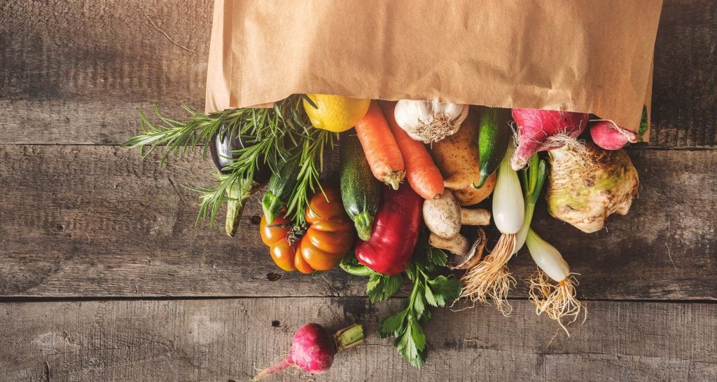 brown grocery bag with various vegetables in it