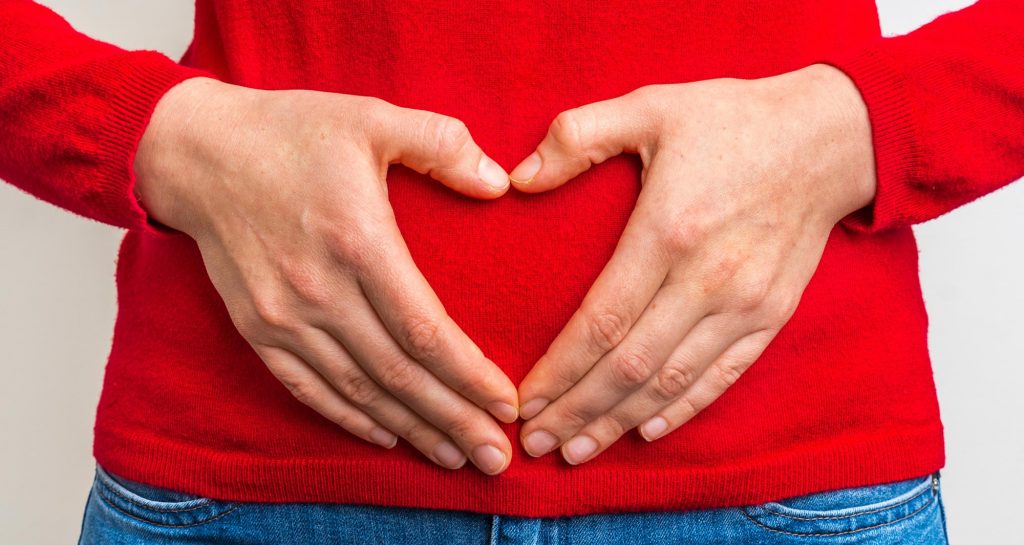 hands in heart shape over the stomach