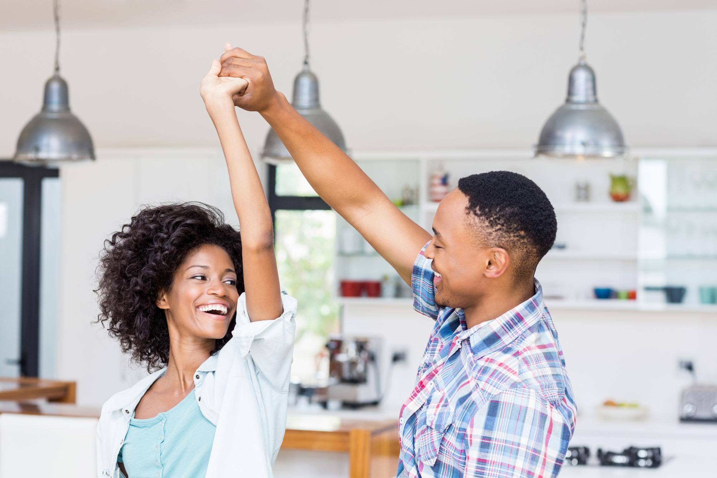 African American couple dancing in kitchen