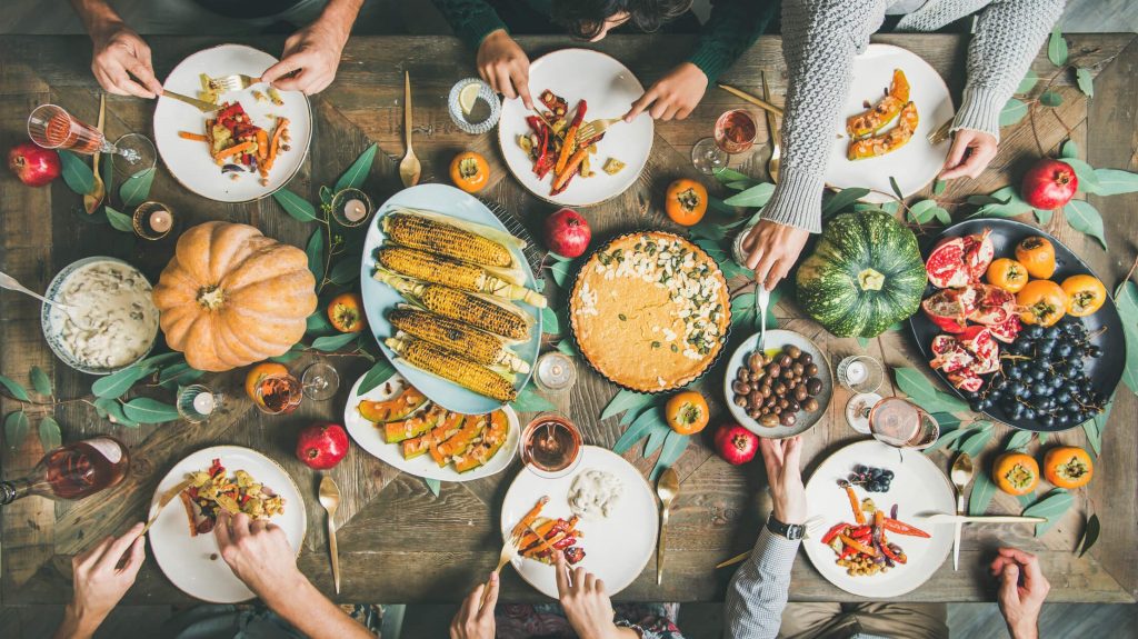 A bird's eye view of a holiday table with a variety of plant-based dishes