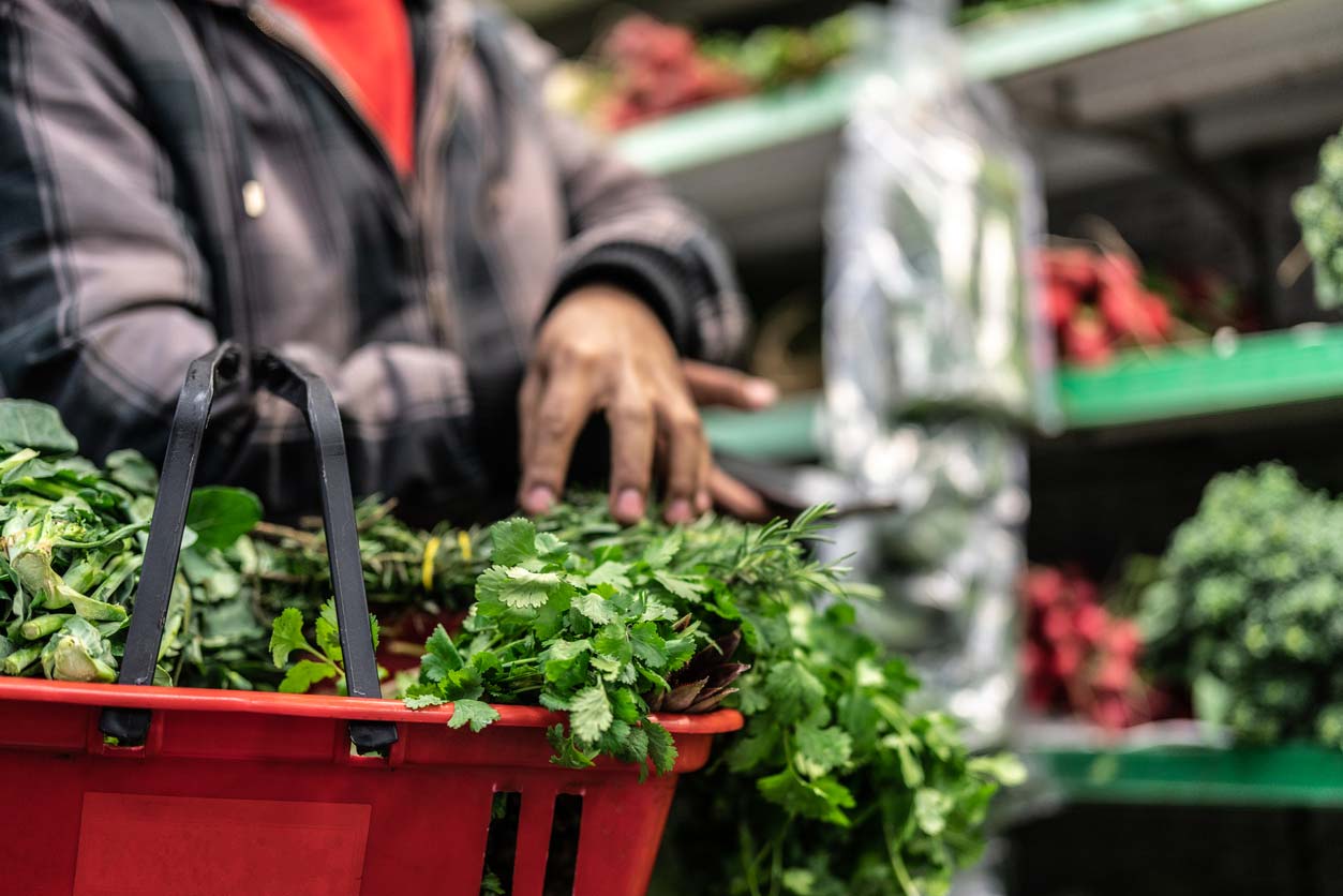 Customer buying greens at supermarket