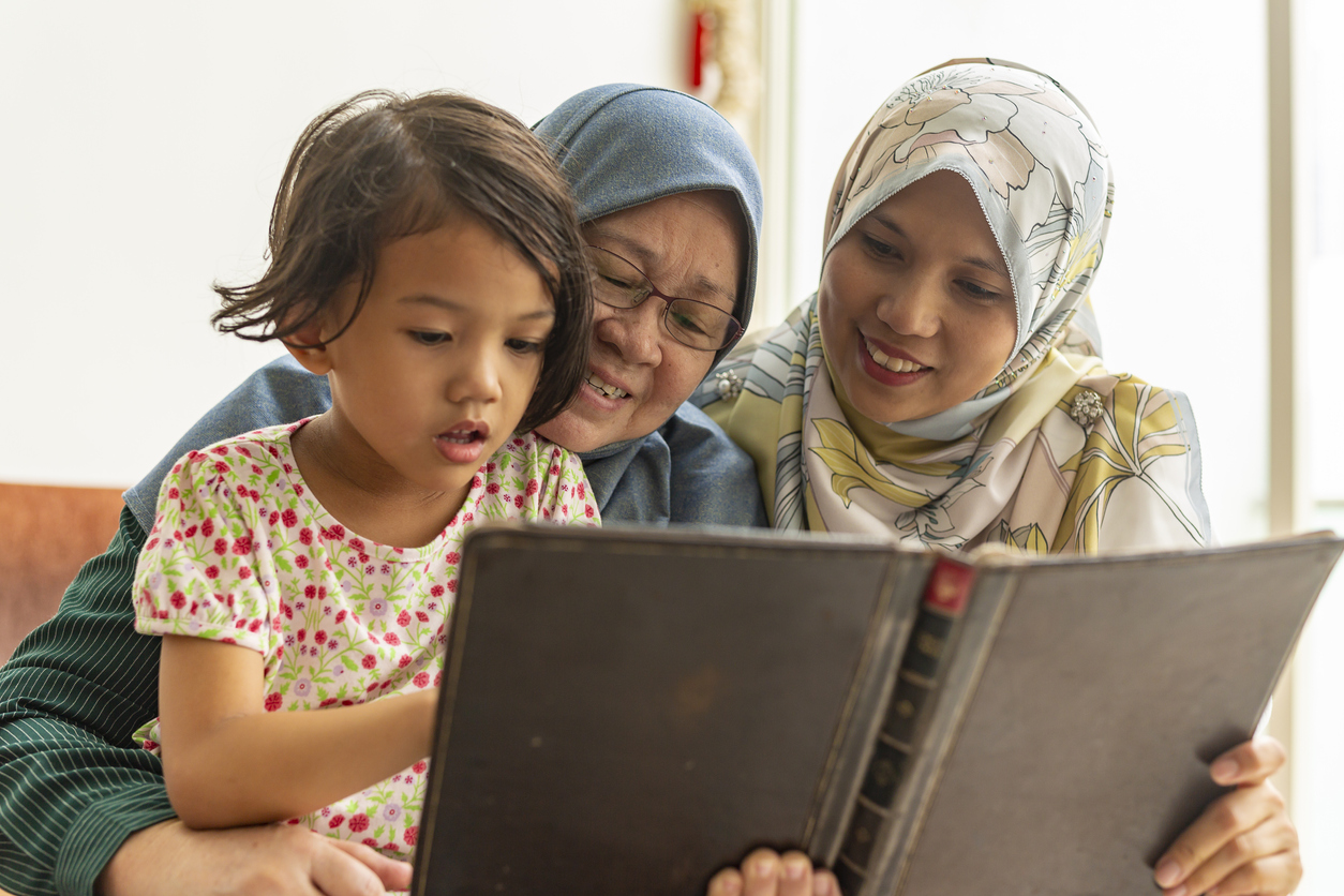 Three Generations of Muslim Women Reading Together