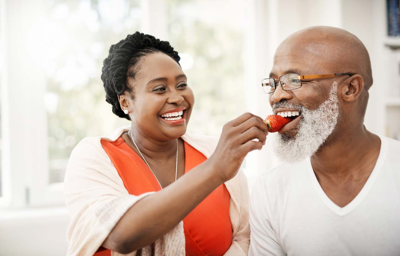 woman feeding man strawberry