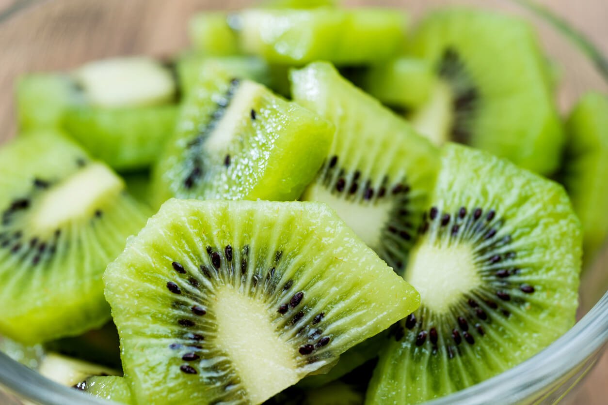 a bowl of kiwi fruit slices on wooden table