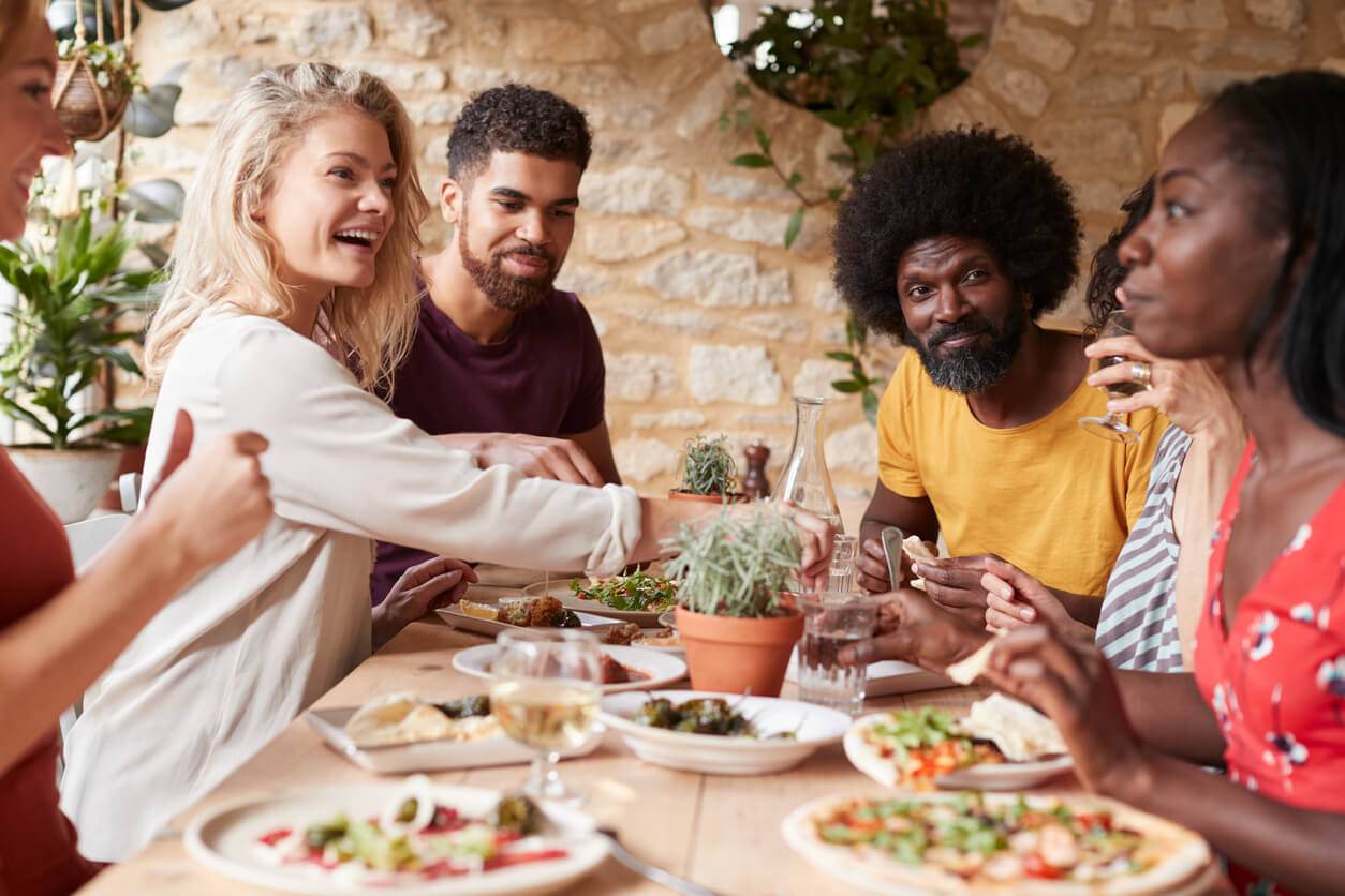 adult friends eating lunch at a table in a restaurant