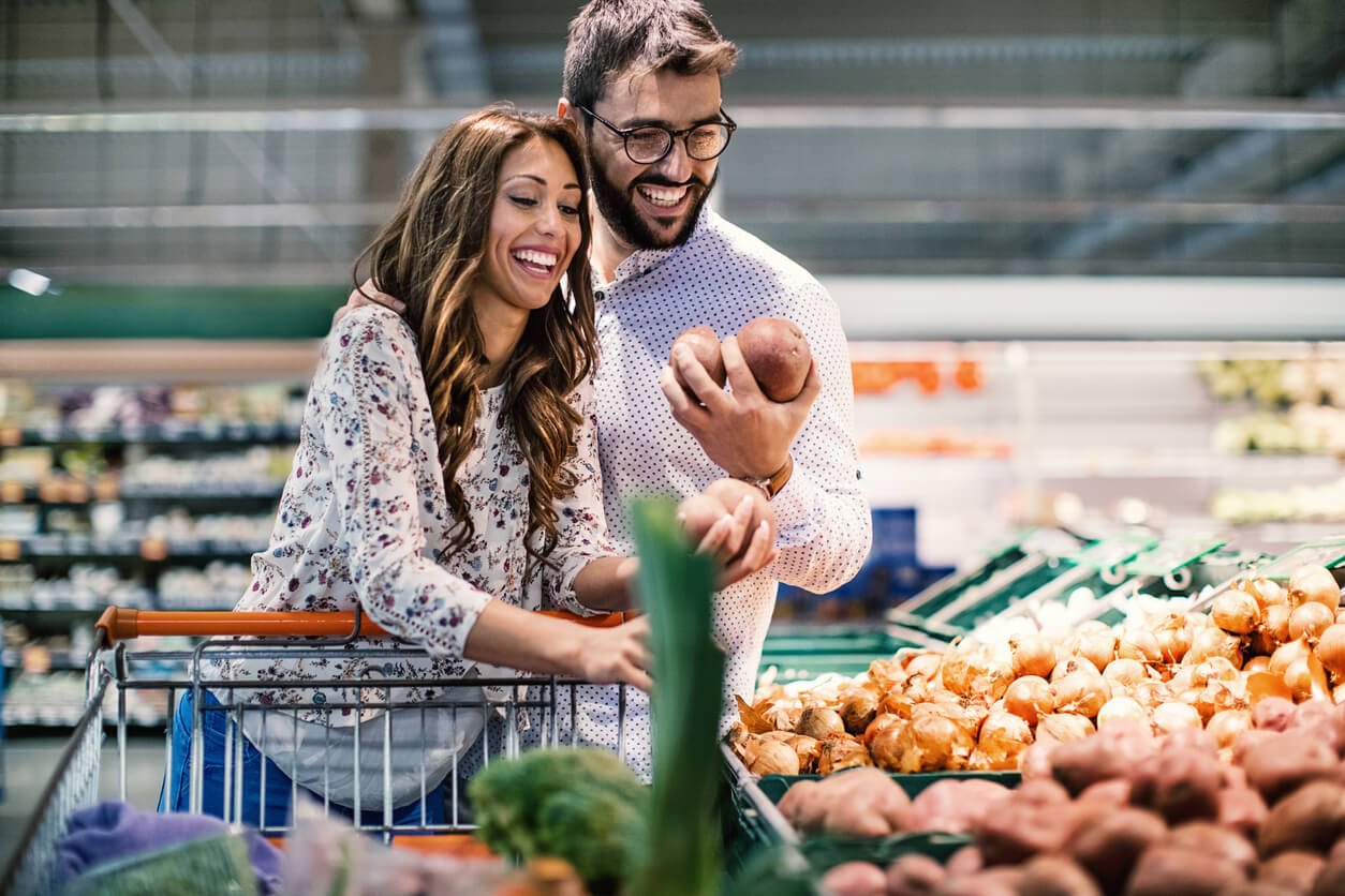 couple in supermarket doing holiday meal planning