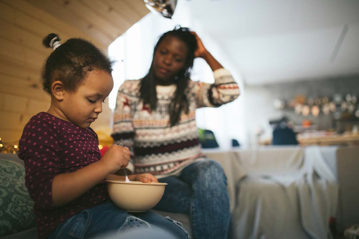 Daughter with bowl of food and worried mom