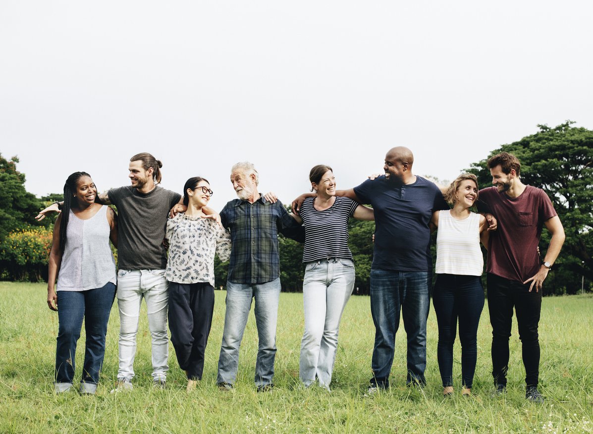 group of people hugging each other in the park