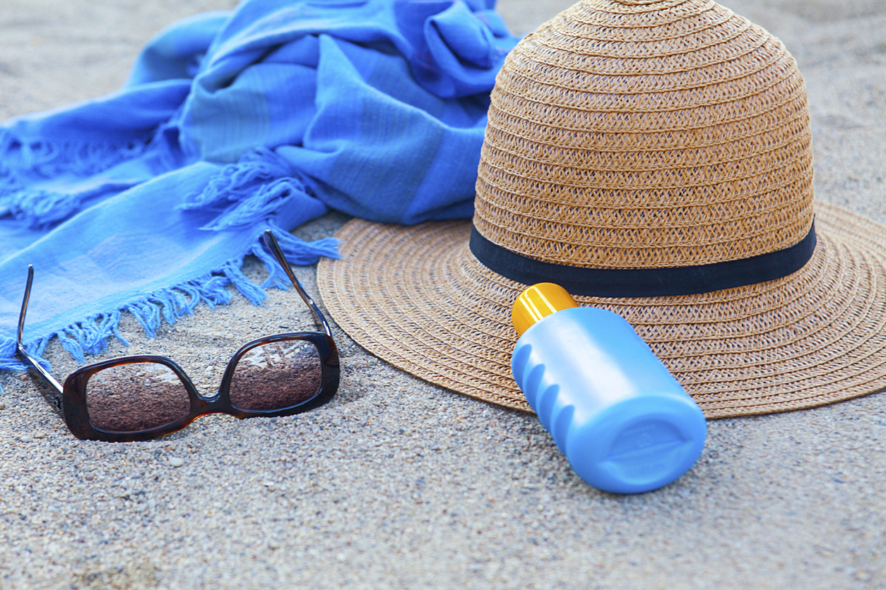 Sunscreen, hat and glasses on beach . Day with sunny in Çeşme,Turkey.