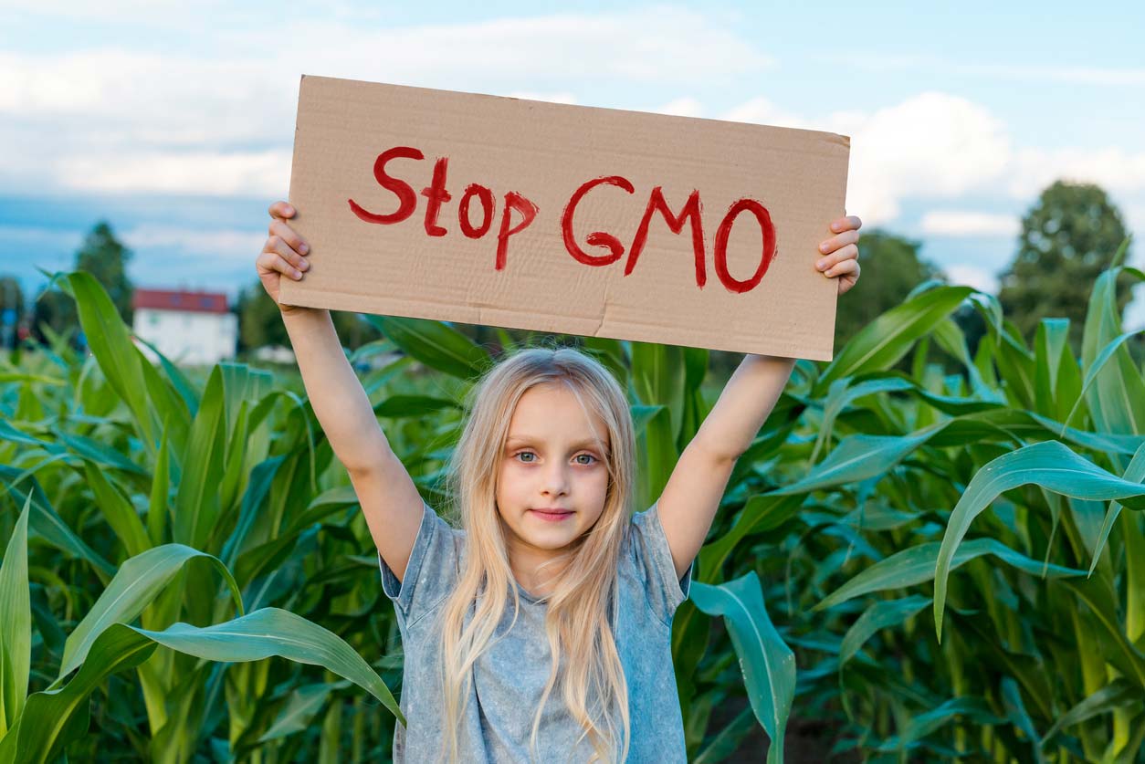 small girl holding stop gmo sign