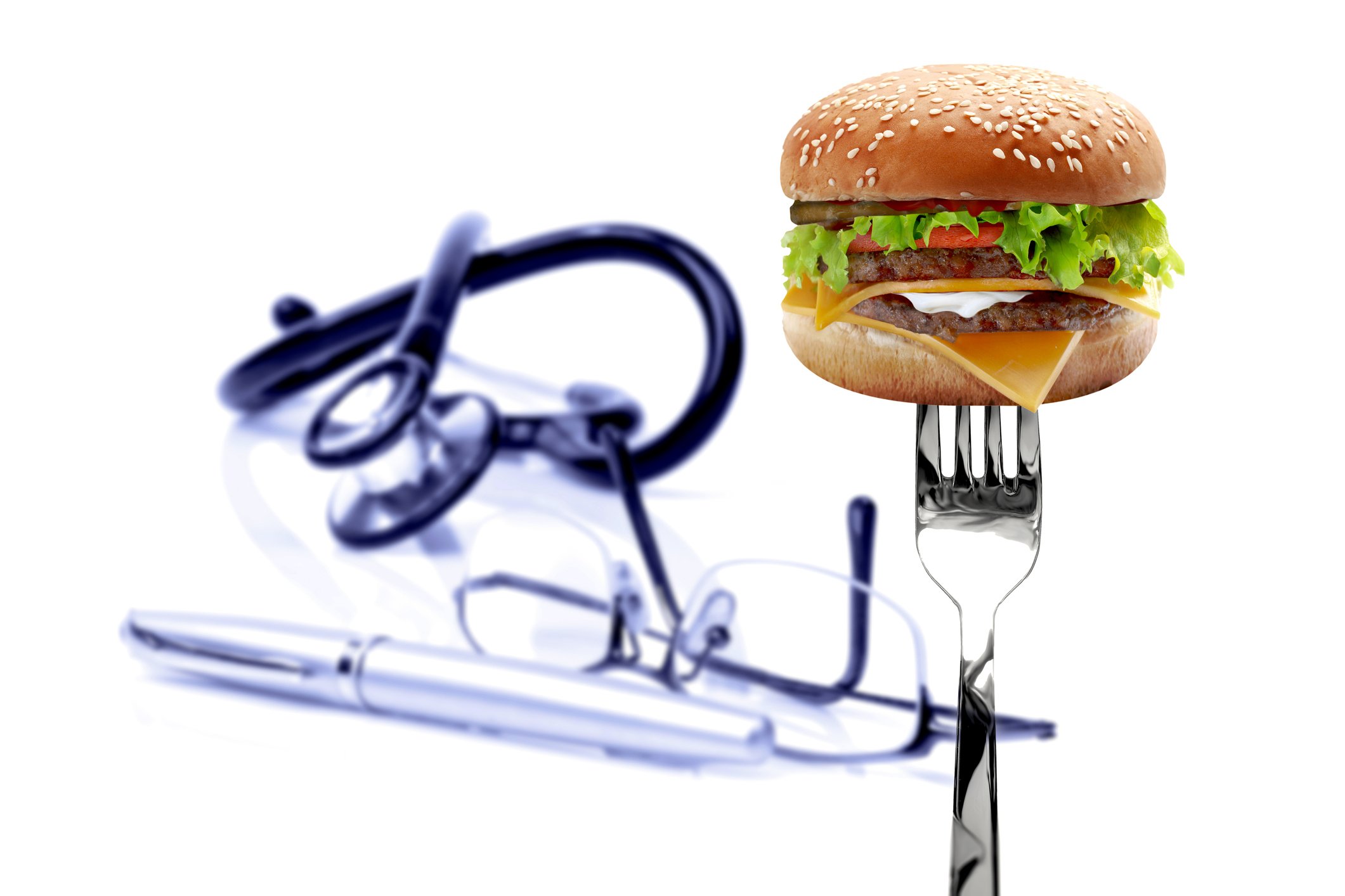 Burger, glasses, a pen and stethoscope on the white background. Unhealthy life concept.