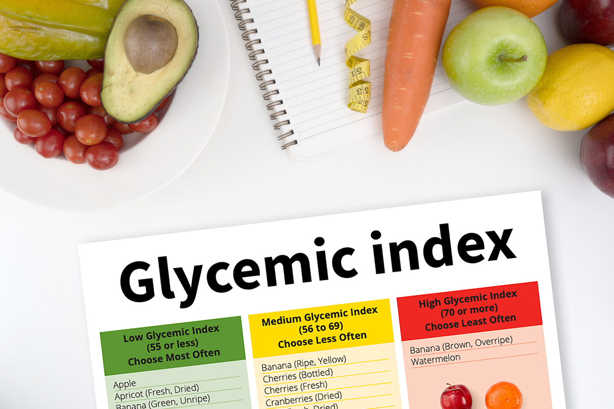 Glycemic index Fitness and weight loss concept, dumbbells, white scale, fruit and tape measure on a wooden table, top view