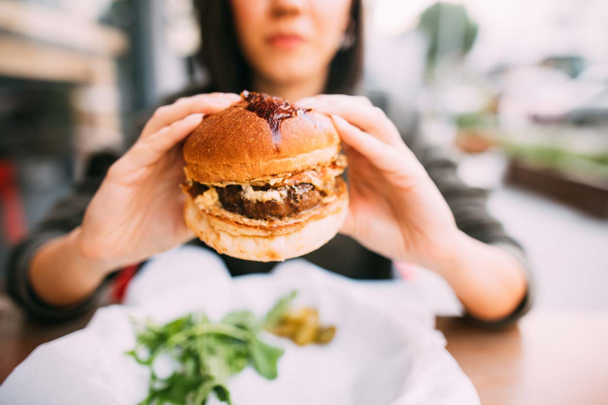 Woman eating grass-fed beef burger