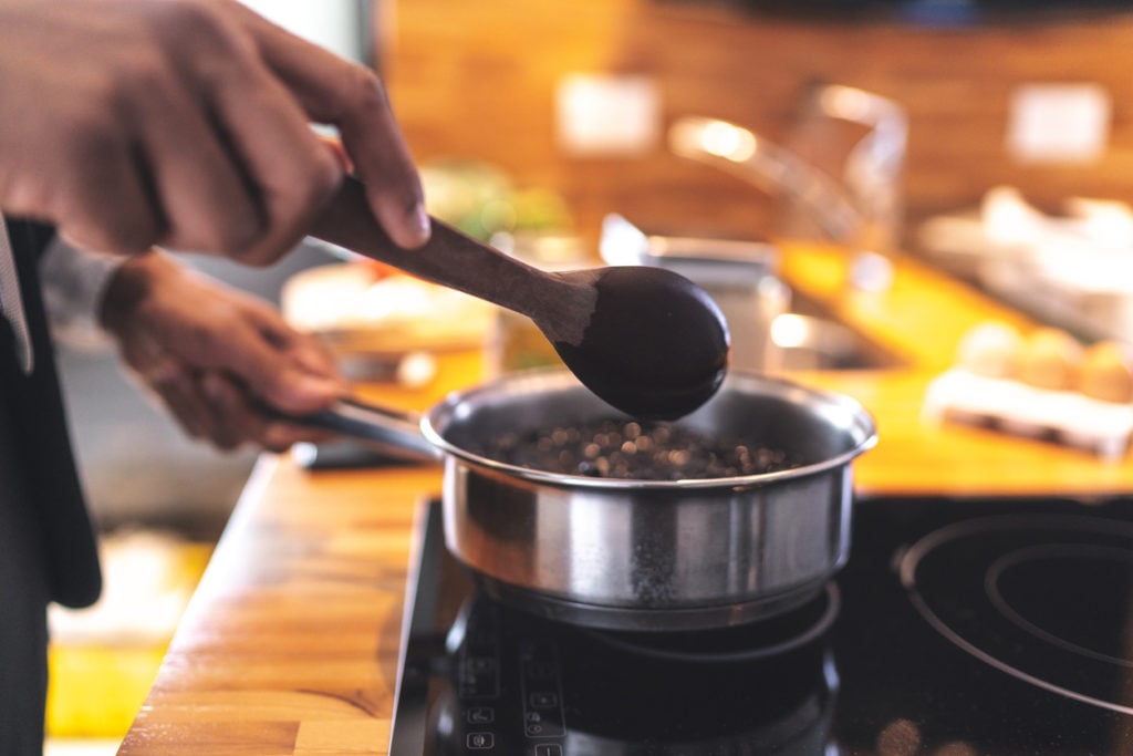 Cooking black beans in a sauce pot on the stove