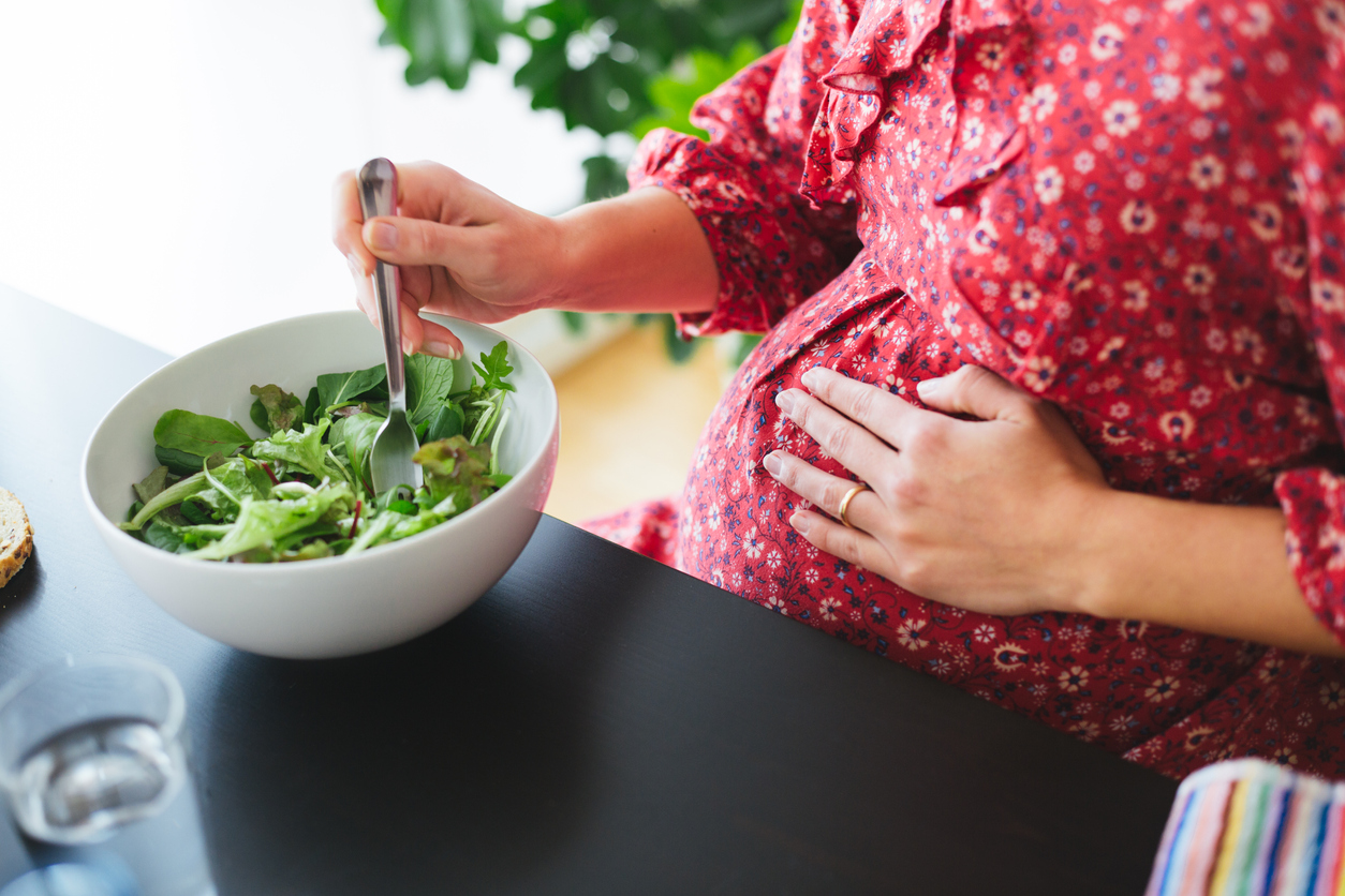 Healthy pregnant woman eating a salad