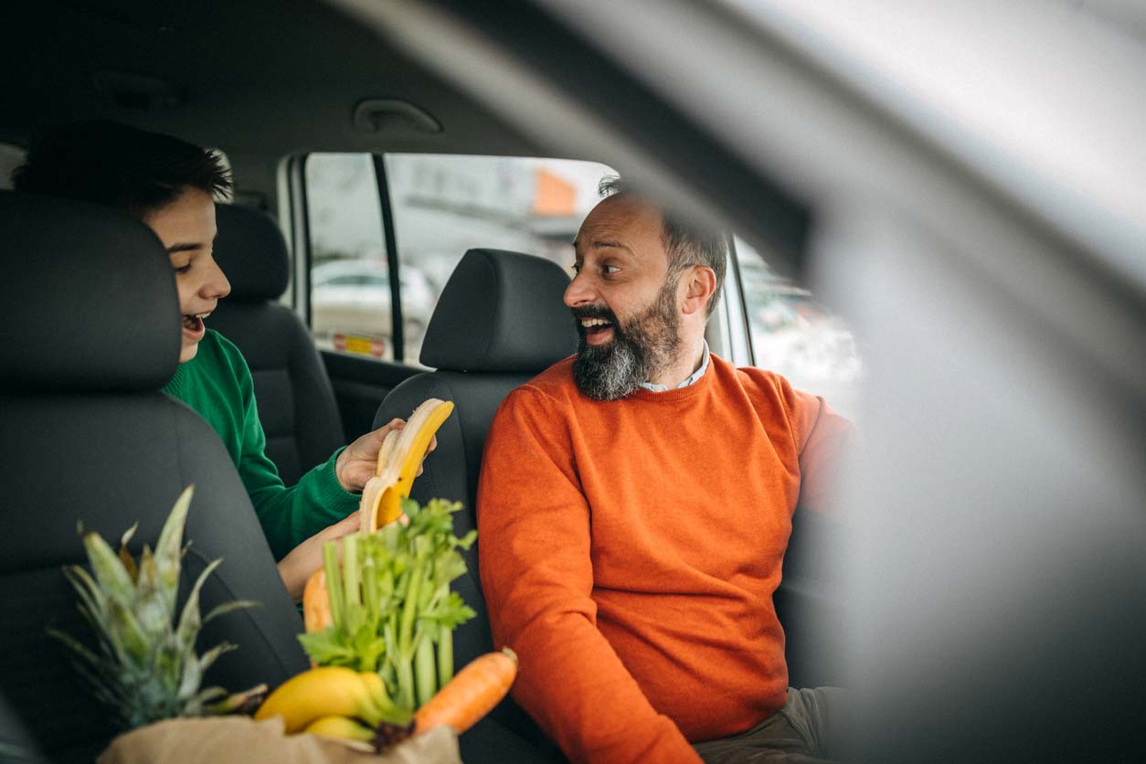 excited father and son in car about to leave