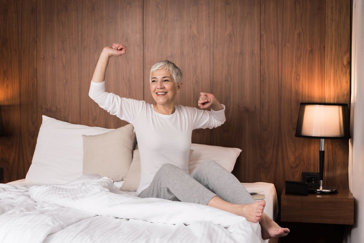 woman stretching in bed after sleeping well