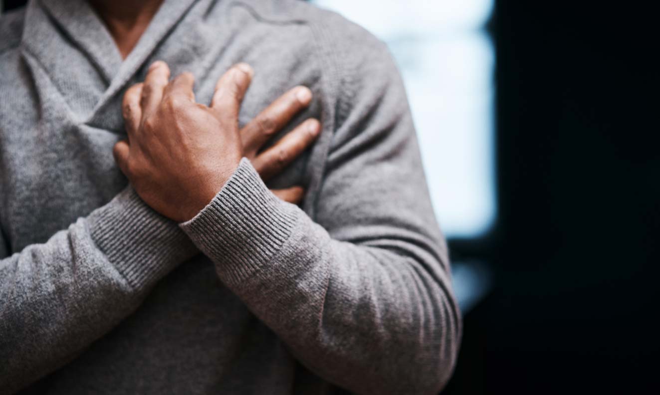 man of color with hands crossed holding chest near heart