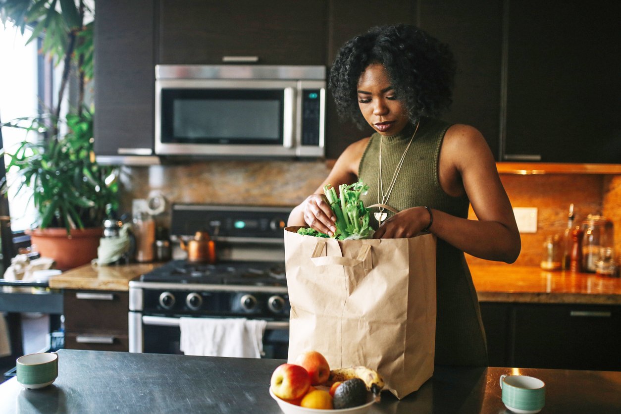 young woman comes home from grocery shopping