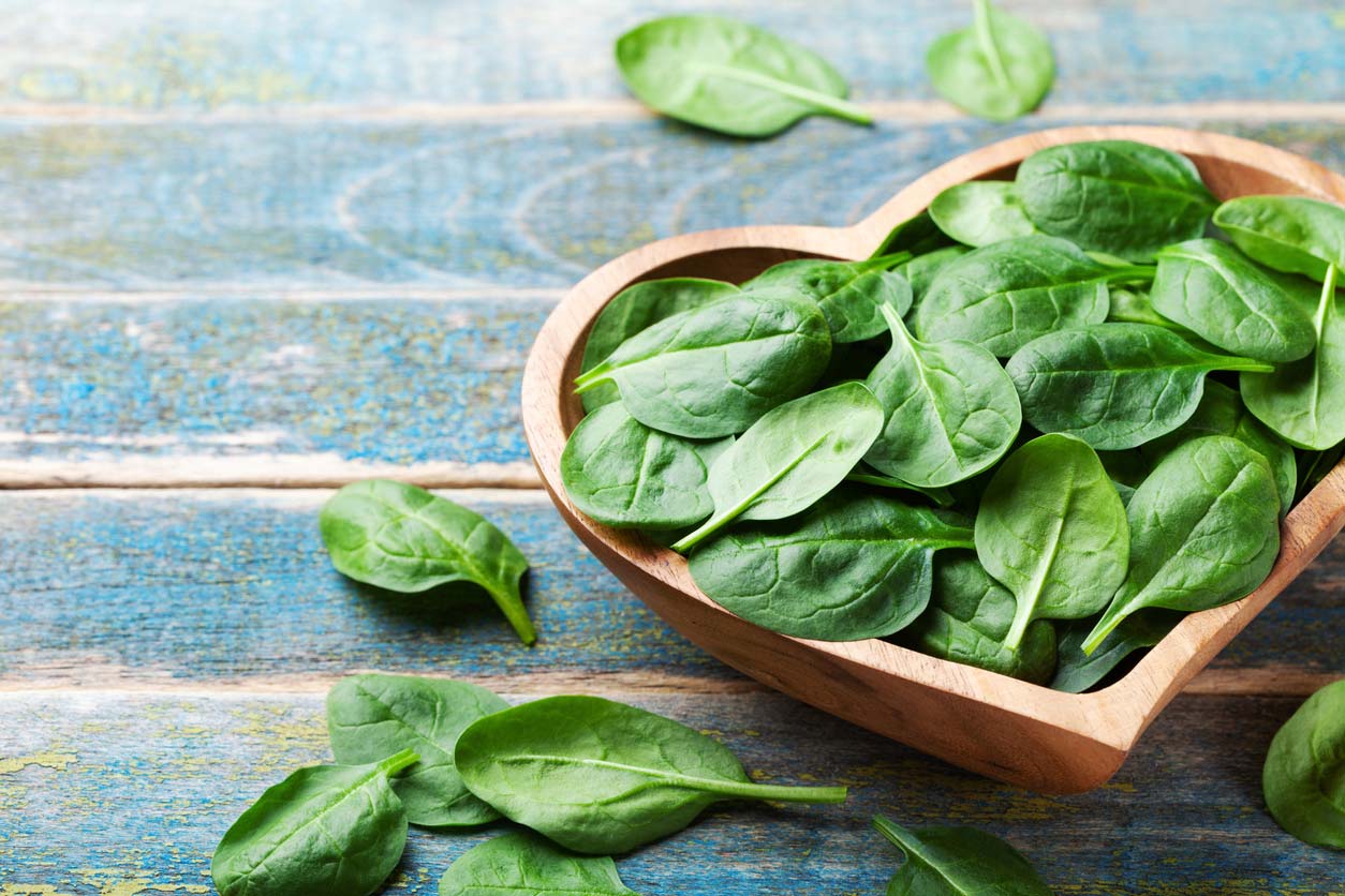 spinach in heart shaped bowl on table