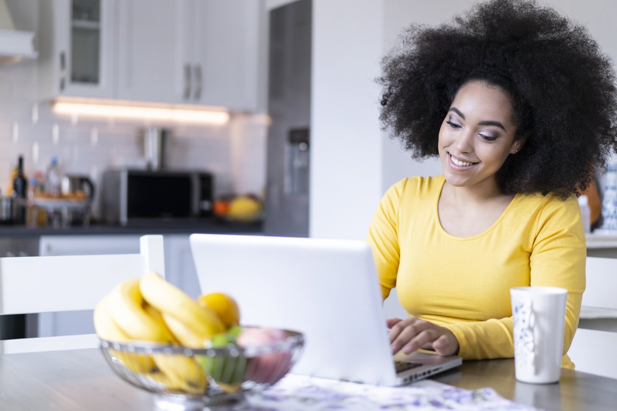 African woman using laptop at home