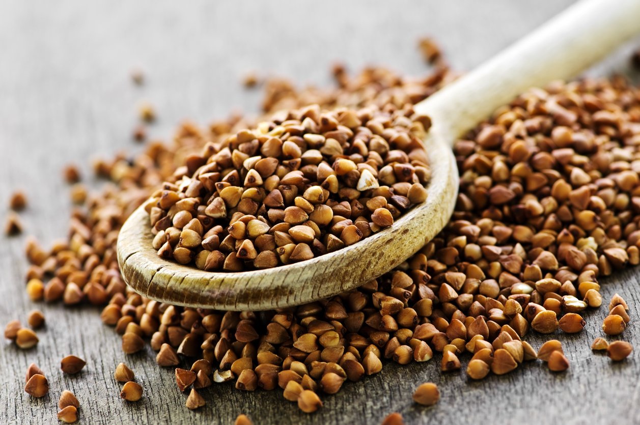 Wooden spoon filled with buckwheat grain