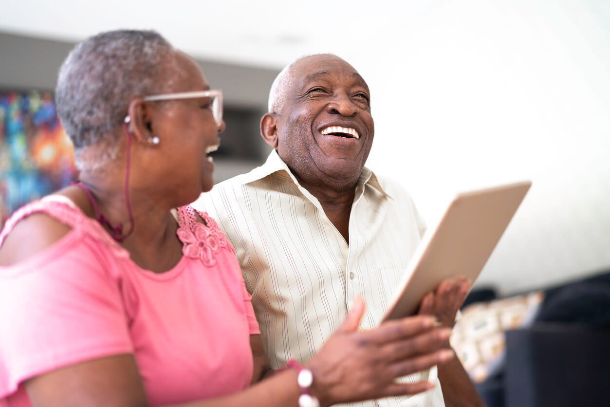 elderly couple laughing at iPad