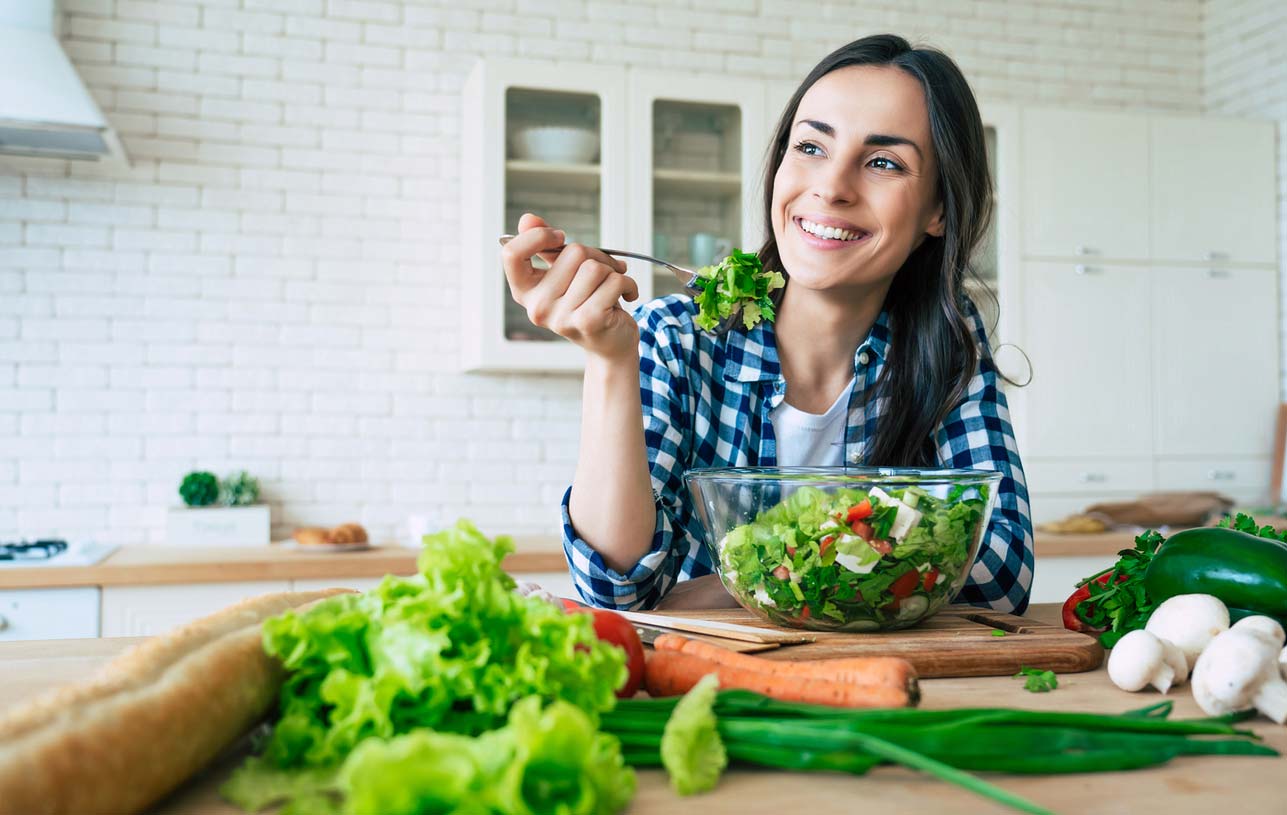 Woman enjoying a healthy salad in the kitchen