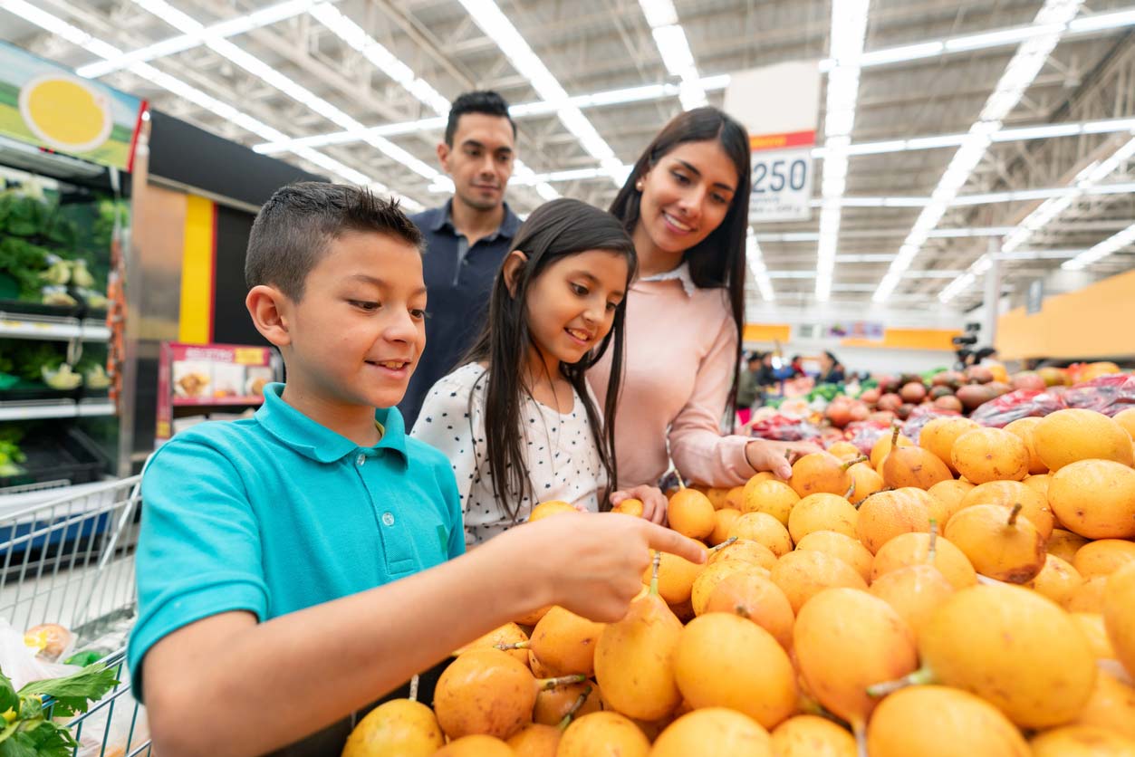 family at supermarket choosing fruits