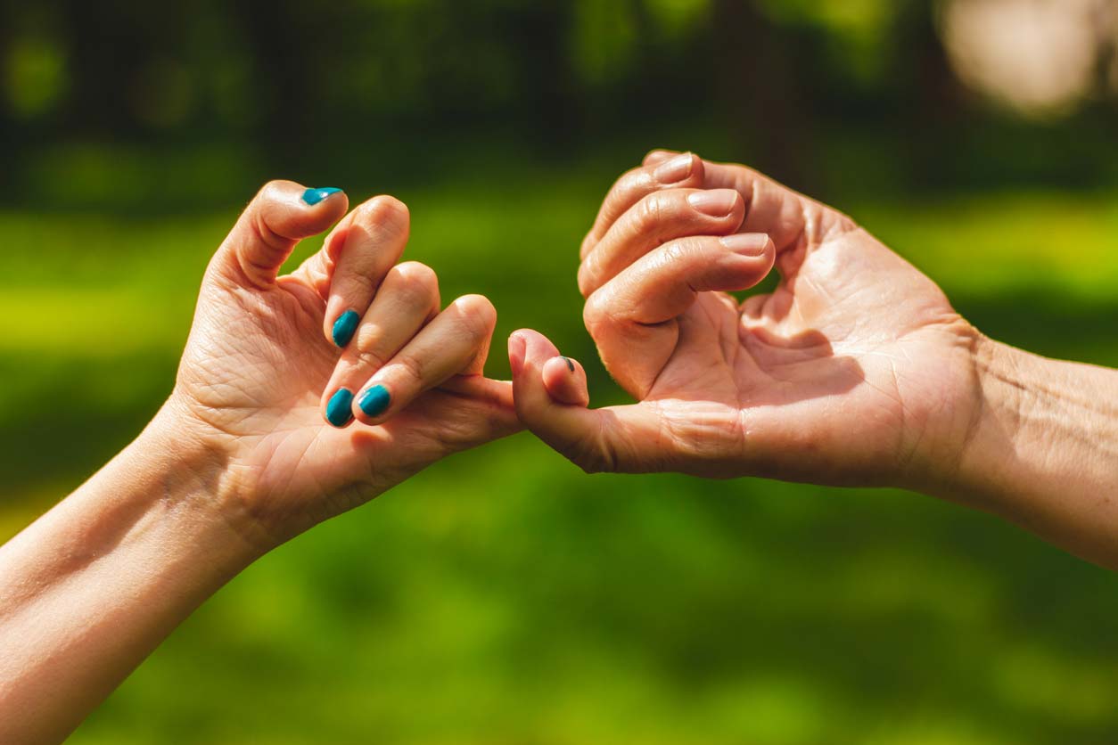 close up of hands in a pinkie-promise