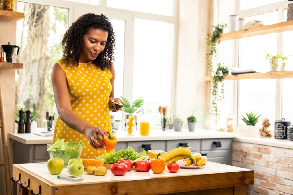 Woman preparing fruits and vegetables in her kitchen