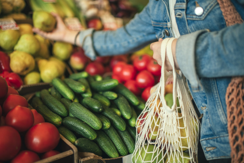Close-up of woman grabbing produce at a food co-op