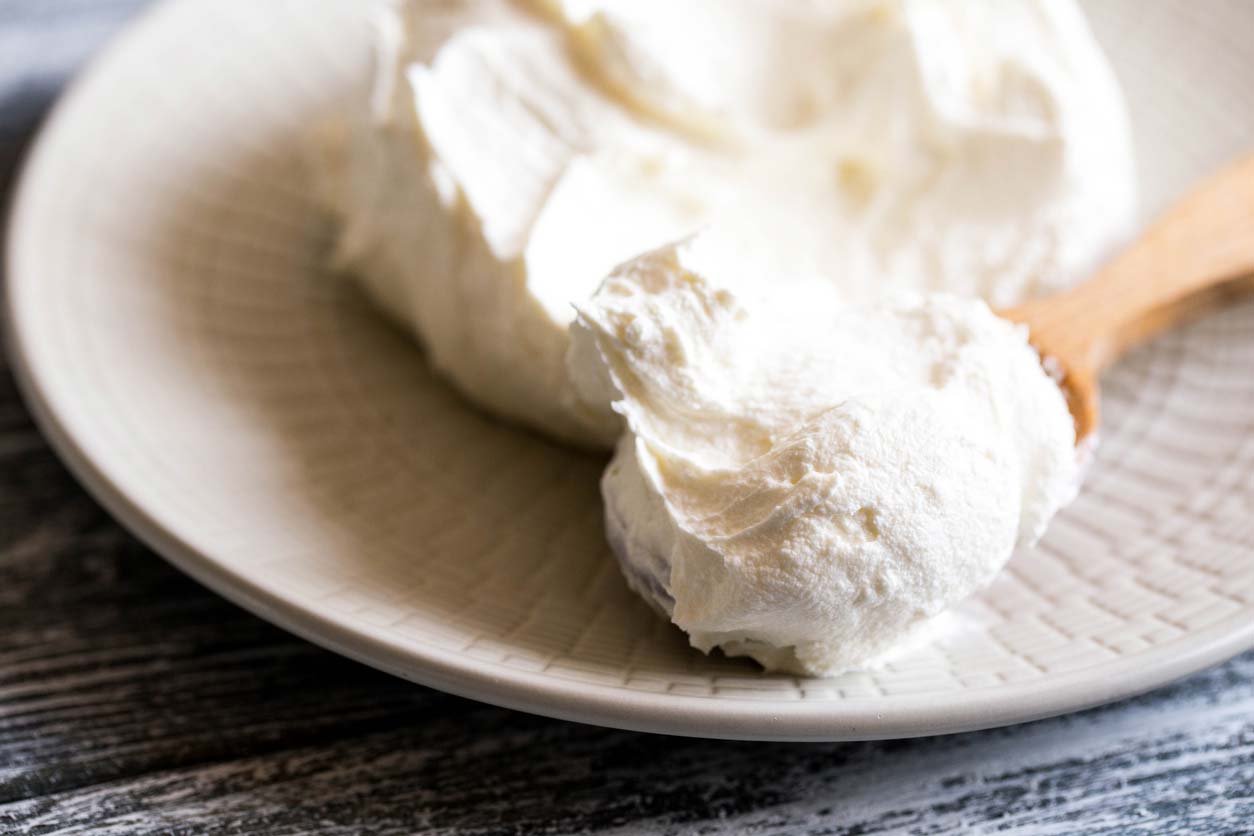 Mascarpone cheese on wooden spoon