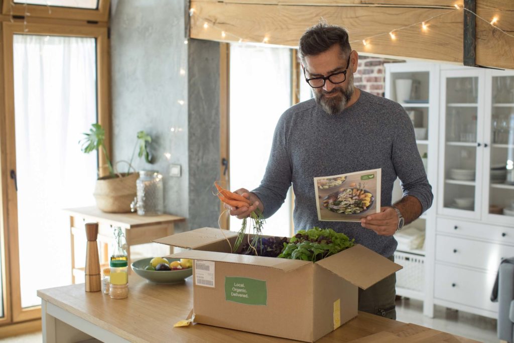 Man unpacking a plant-based meal delivery kit