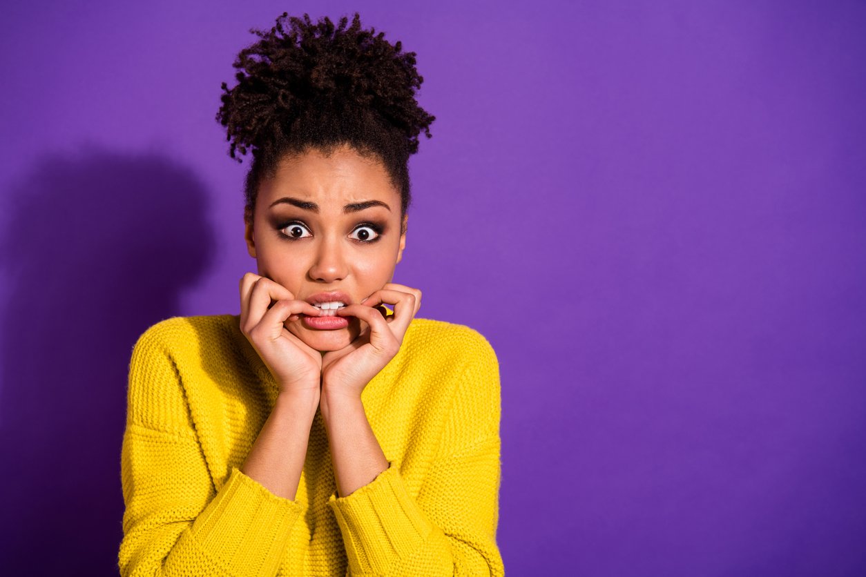 Portrait of terrified beautiful, youth nails bite hear horrible news wear stylish trendy pullover jumper isolated over purple violet background