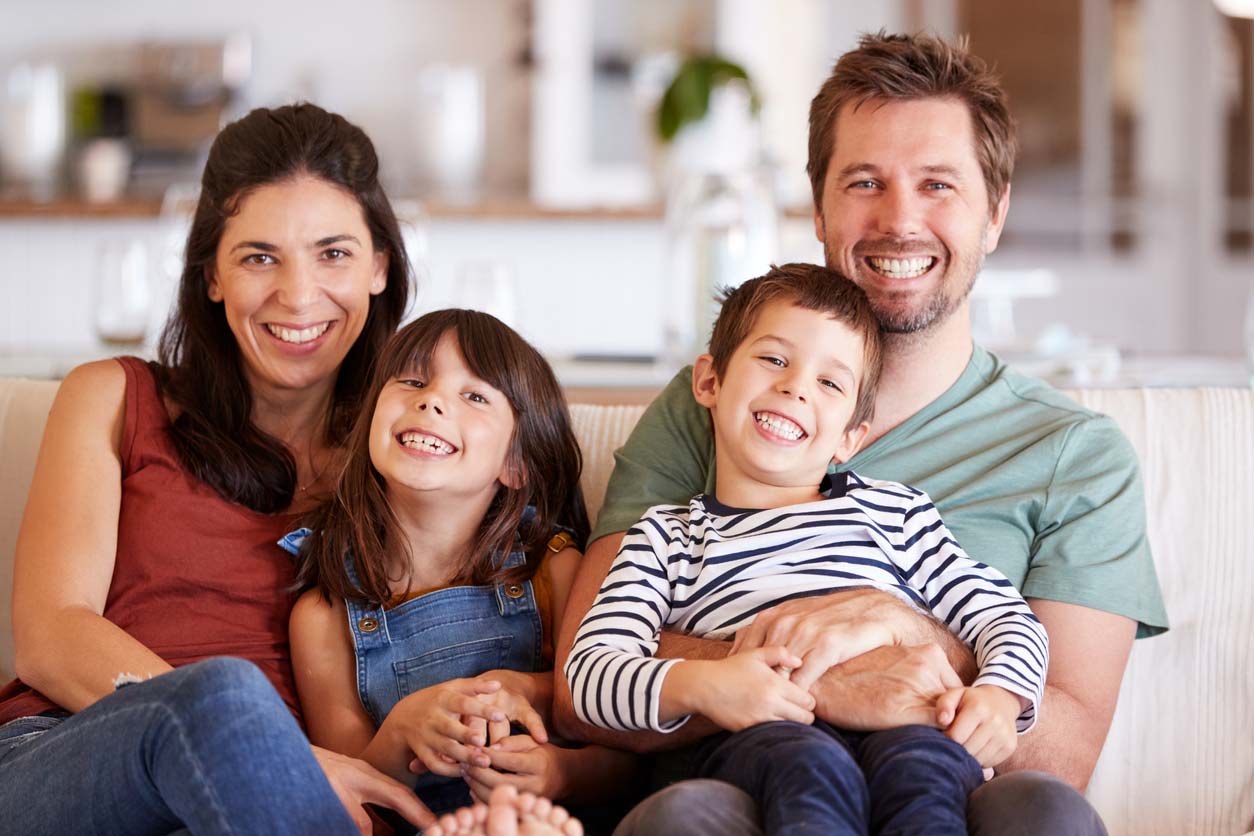 family smiling together on couch